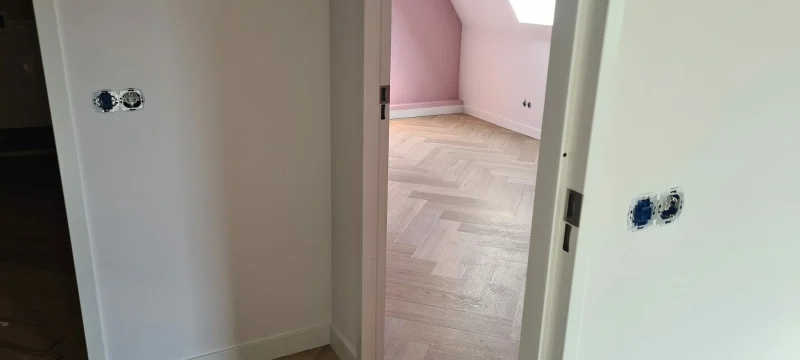 Visgraat PVC-vloer in een slaapkamer onder een schuin dak