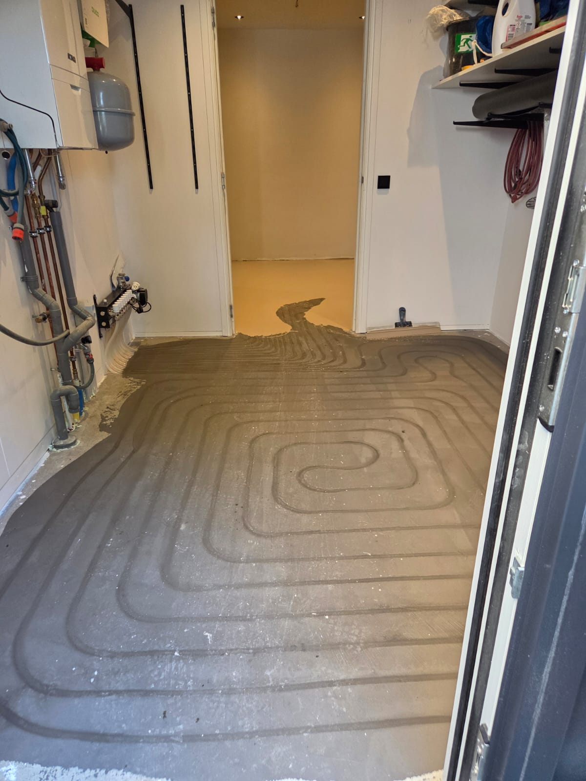 Ingefreesde vloerverwarming in een spiraalpatroon, nog voor het egaliseren